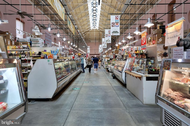 misc room featuring a towering ceiling, a workshop area, concrete floors, and ceiling fan