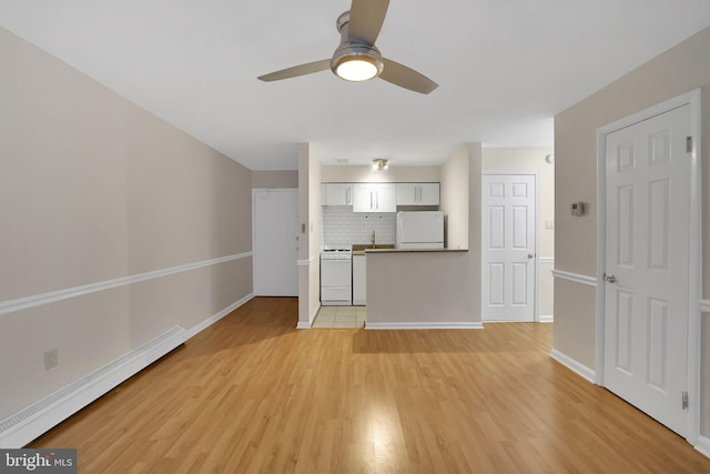 unfurnished living room with baseboard heating, ceiling fan, and light wood-type flooring