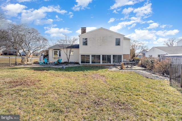 back of property featuring a sunroom and a lawn