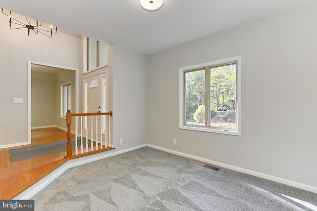 spare room featuring an inviting chandelier and carpet