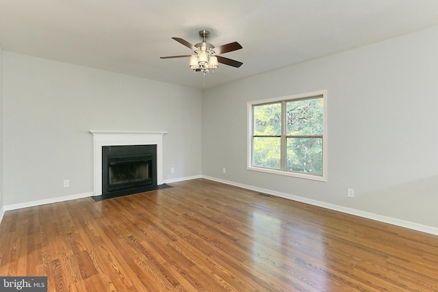 unfurnished living room with ceiling fan and hardwood / wood-style floors