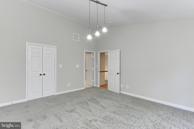 unfurnished room featuring high vaulted ceiling and carpet floors