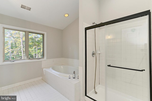 bathroom featuring tile patterned flooring, vaulted ceiling, and separate shower and tub