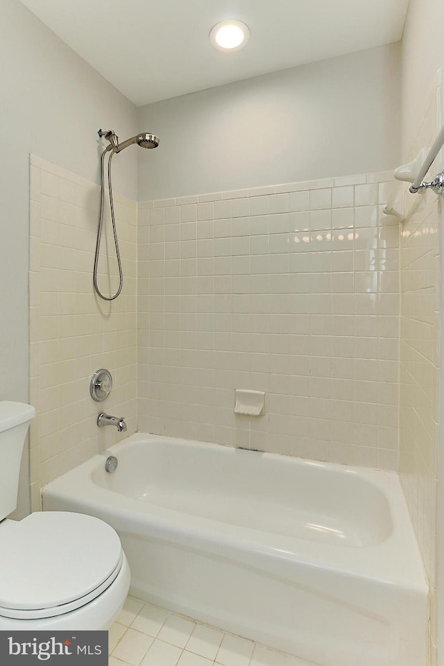 bathroom with tiled shower / bath, tile patterned floors, and toilet