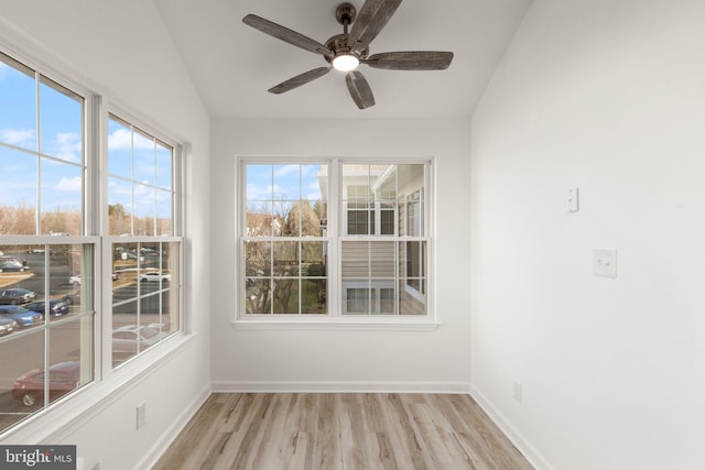 unfurnished sunroom featuring ceiling fan