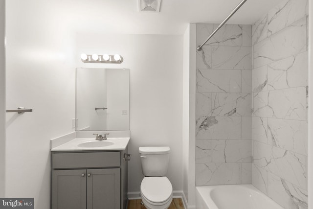 full bathroom featuring tiled shower / bath combo, vanity, and toilet