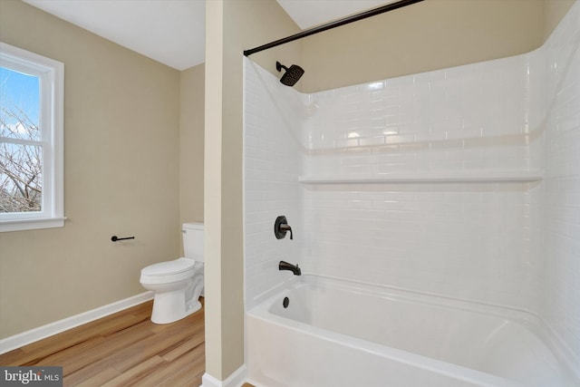 bathroom with hardwood / wood-style flooring, tiled shower / bath, and toilet