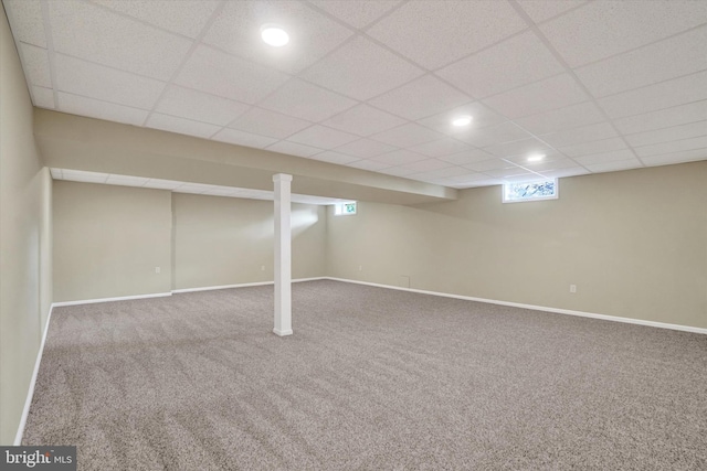 basement featuring a paneled ceiling and carpet