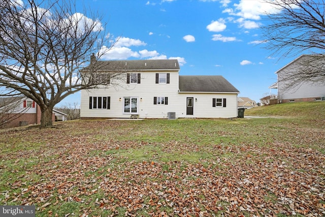 rear view of property with central AC unit and a lawn