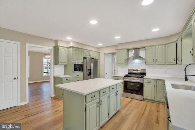 kitchen featuring appliances with stainless steel finishes, wall chimney range hood, and green cabinetry