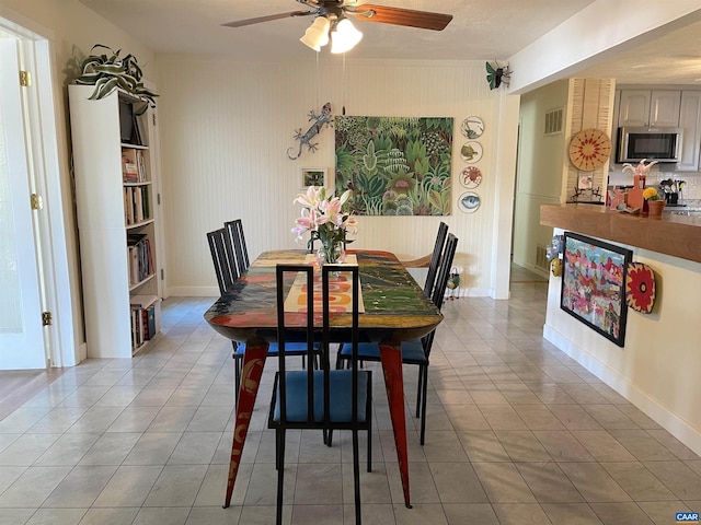 tiled dining space featuring ceiling fan