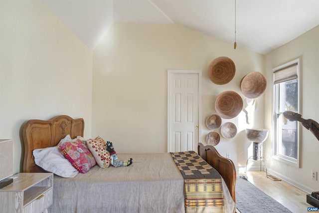 bedroom with lofted ceiling and light hardwood / wood-style floors