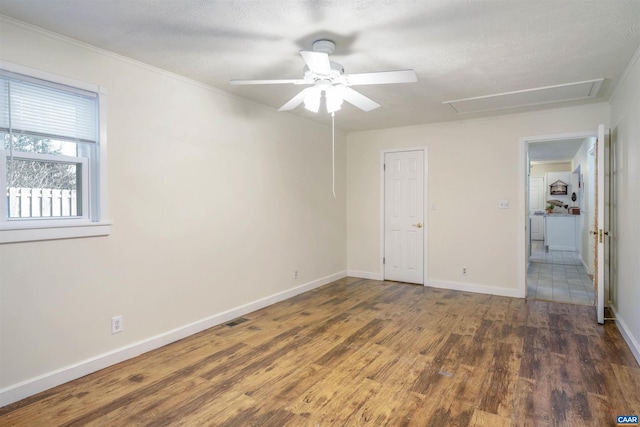 empty room with crown molding, ceiling fan, dark hardwood / wood-style flooring, and a textured ceiling