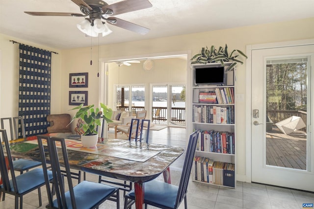 dining space featuring french doors, ceiling fan, and light tile patterned flooring