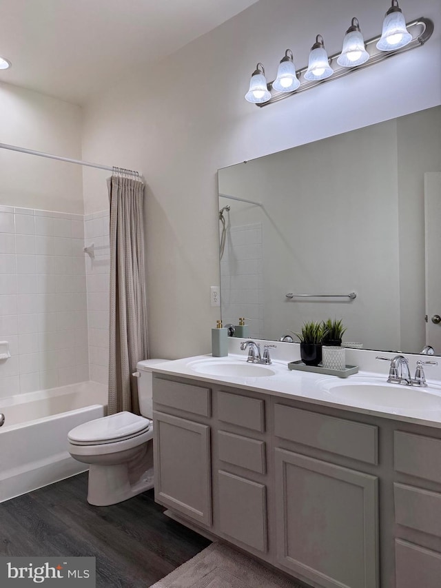 full bathroom featuring wood-type flooring, toilet, shower / tub combo, and vanity