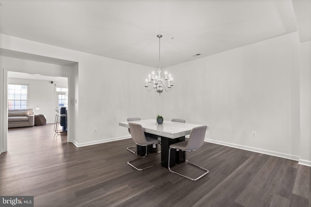 dining space featuring an inviting chandelier and dark hardwood / wood-style flooring