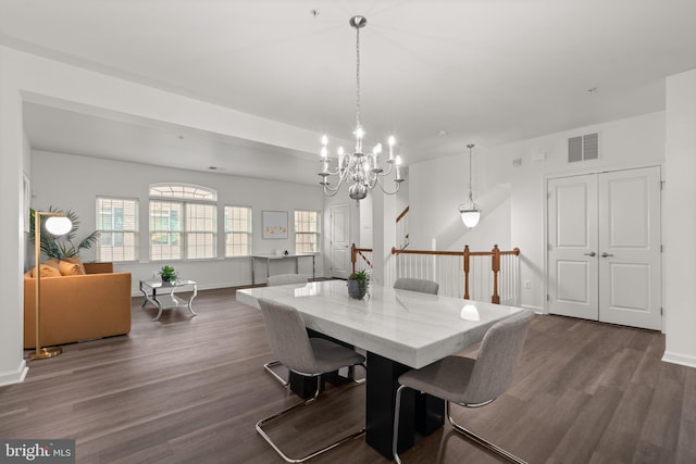 dining space featuring a notable chandelier and dark hardwood / wood-style flooring