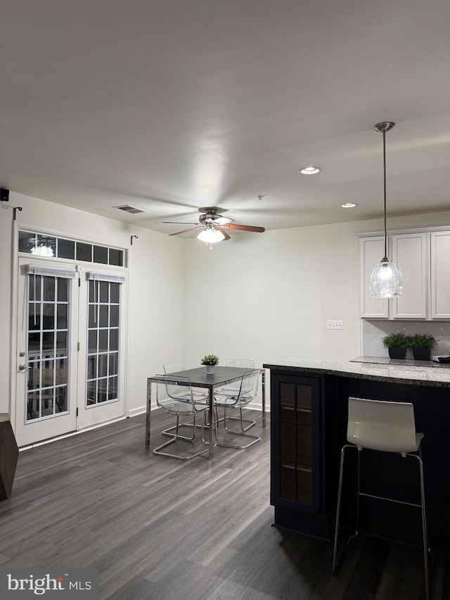 kitchen with white cabinetry, decorative light fixtures, dark hardwood / wood-style flooring, ceiling fan, and decorative backsplash