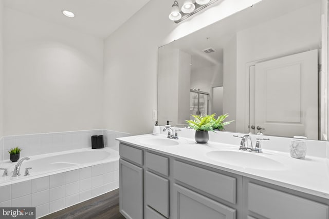 bathroom featuring vanity, hardwood / wood-style flooring, and separate shower and tub