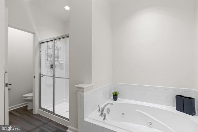 bathroom with hardwood / wood-style flooring, toilet, and separate shower and tub