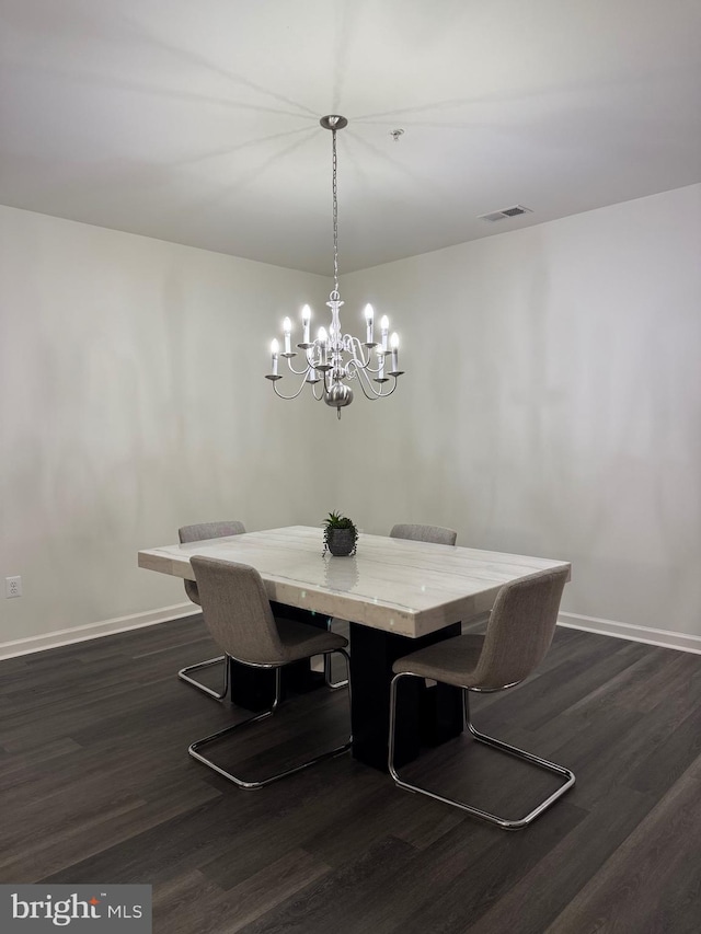 dining area featuring dark hardwood / wood-style flooring and a notable chandelier