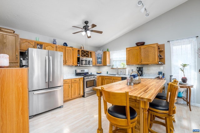 kitchen featuring stainless steel appliances, sink, light hardwood / wood-style floors, and decorative backsplash