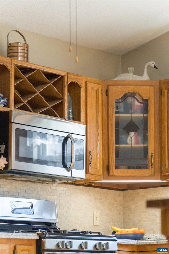 kitchen with tasteful backsplash and appliances with stainless steel finishes