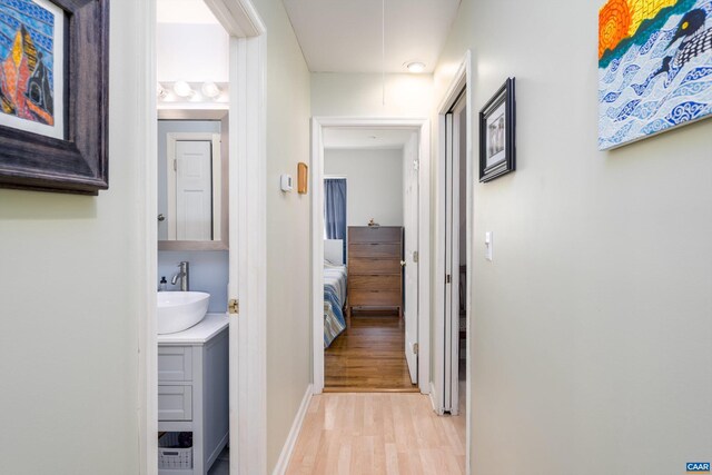 hall featuring sink and light wood-type flooring