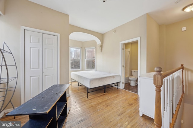 interior space with connected bathroom, light hardwood / wood-style floors, and a closet