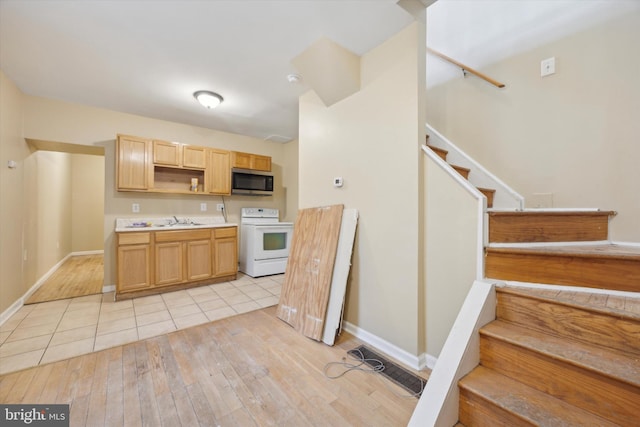 kitchen featuring light brown cabinetry, sink, light hardwood / wood-style floors, and white range with electric cooktop