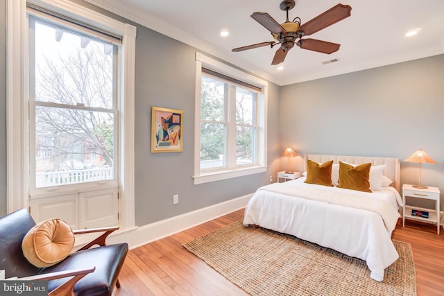 bedroom featuring light hardwood / wood-style flooring, ornamental molding, and ceiling fan