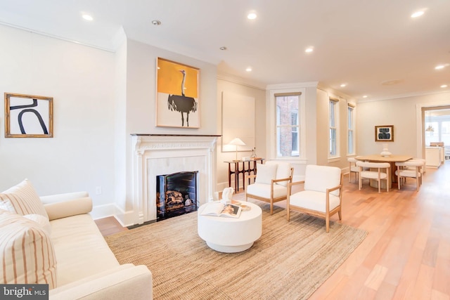 living room with ornamental molding and light hardwood / wood-style flooring