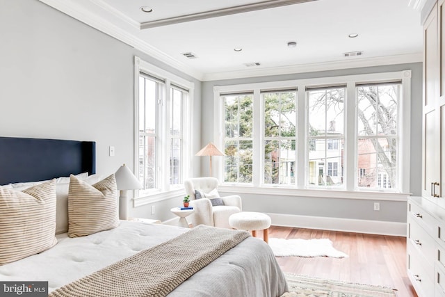 bedroom with multiple windows, ornamental molding, and light wood-type flooring