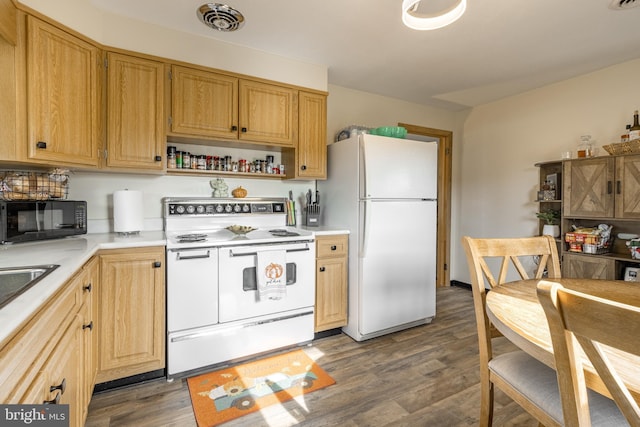 kitchen featuring white appliances and dark hardwood / wood-style floors