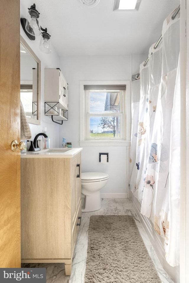 bathroom with vanity, plenty of natural light, and toilet