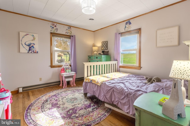 bedroom featuring crown molding, baseboard heating, and hardwood / wood-style floors