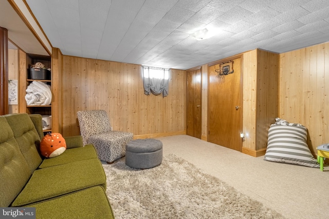 living area featuring carpet floors and wooden walls