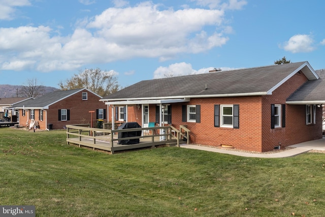 back of property with a deck and a lawn