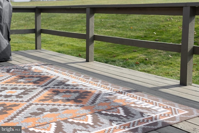 wooden terrace featuring a lawn