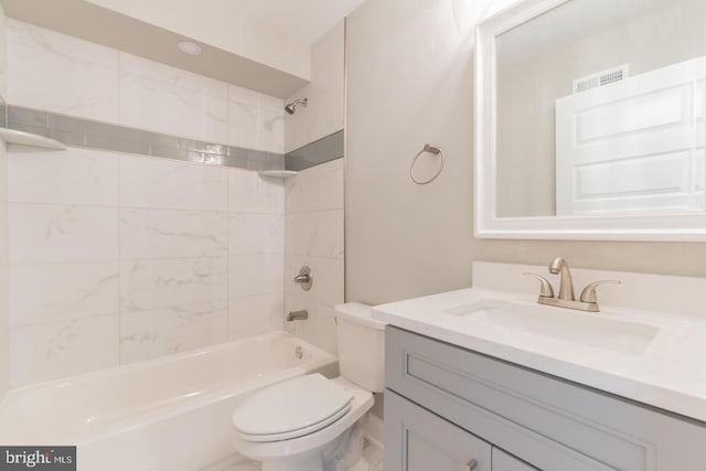 full bathroom with tiled shower / bath, vanity, and toilet