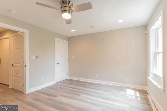 unfurnished bedroom with multiple windows, ceiling fan, and light wood-type flooring