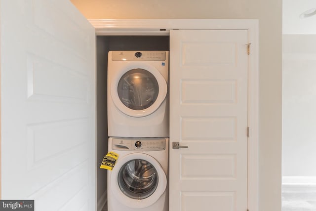 washroom with stacked washing maching and dryer