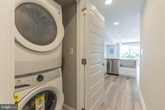 laundry area featuring stacked washer and dryer and light hardwood / wood-style floors