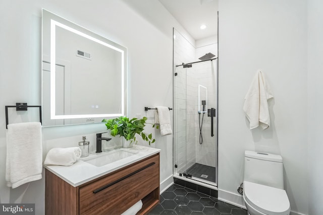 bathroom featuring tile patterned flooring, vanity, a shower with shower door, and toilet