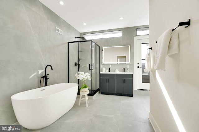 bathroom featuring vanity, shower with separate bathtub, and tile walls