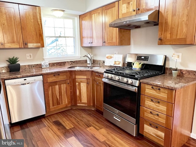 kitchen featuring sink, stainless steel appliances, dark hardwood / wood-style floors, and light stone countertops