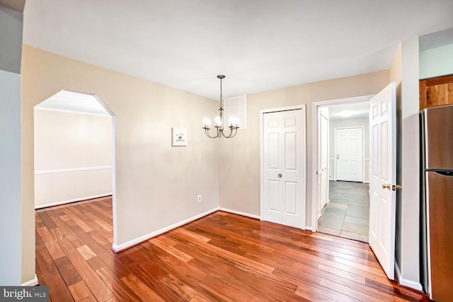 unfurnished dining area with hardwood / wood-style flooring and an inviting chandelier