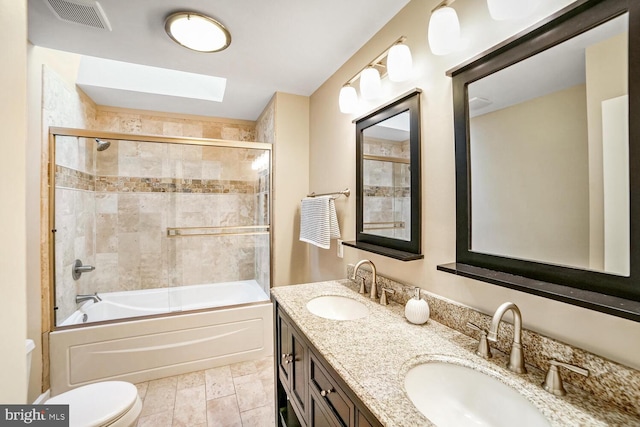 full bathroom with enclosed tub / shower combo, vanity, toilet, and a skylight