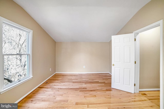 additional living space featuring plenty of natural light, vaulted ceiling, and light hardwood / wood-style flooring