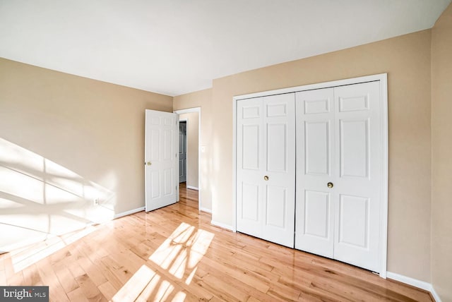 unfurnished bedroom featuring light hardwood / wood-style floors and a closet